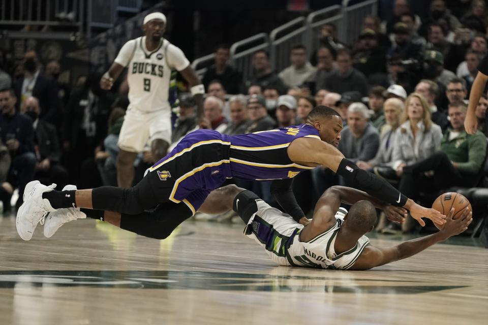 Milwaukee Bucks' Khris Middleton and Los Angeles Lakers' Russell Westbrook battle for a loose ball during the first half of an NBA basketball game Wednesday, Nov. 17, 2021, in Milwaukee. (AP Photo/Morry Gash)