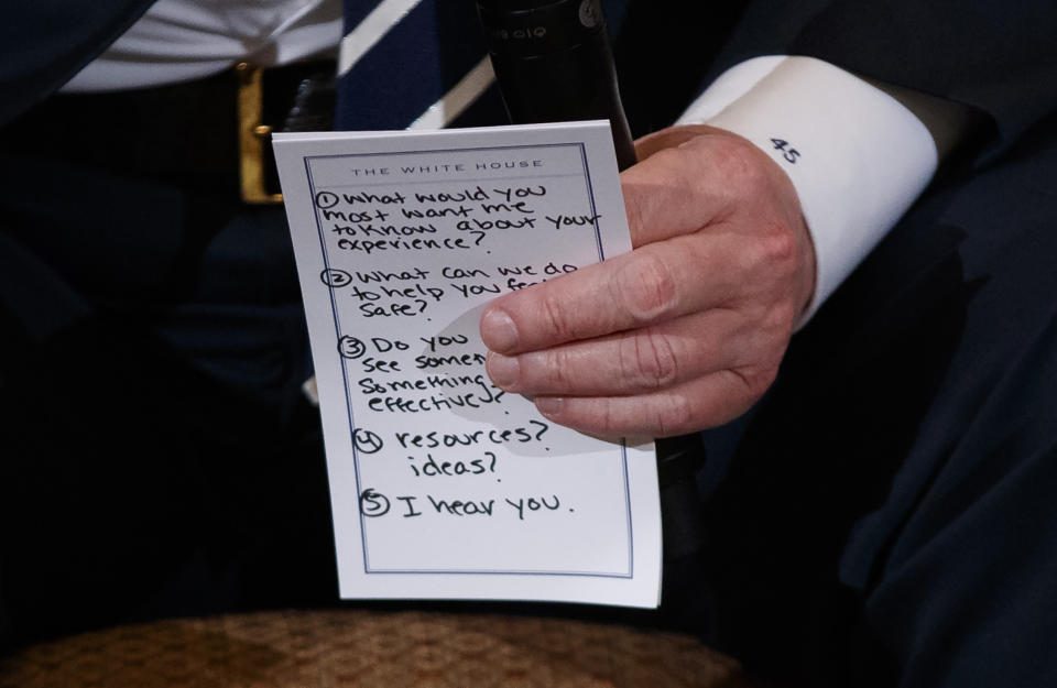 El presidente Donald Trump sostiene las notas escritas en papel que llevó a su encuentro con sobrevivientes y familiares de víctimas de tiroteos masivos en EEUU. (AP)