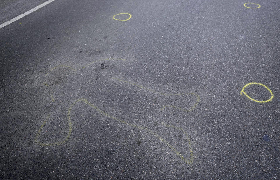 The outlines of a person are seen on a lane of a junction at the Kaiser Wilhelm Memorial Church in Berlin, Germany, Thursday, June 9, 2022. On Wednesday June 8, a 29-year-old man drove his car into a group of students killing their teacher and crash into a store. (AP Photo/Michael Sohn)