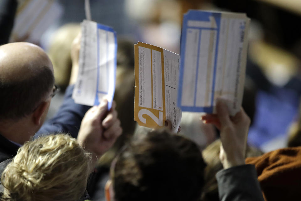 Precinct 68 Iowa Caucus voters seated in the Biden section hold up their first votes as they of the caucus as they are counted at the Knapp Center on the Drake University campus in Des Moines, Iowa, Monday, Feb. 3, 2020. (Gene J. Puskar/AP)