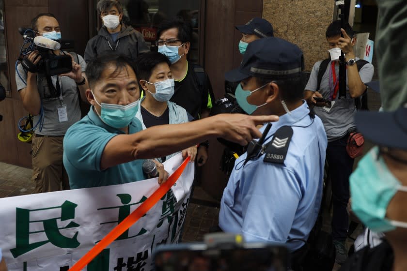 Police officers stop members of the Democratic Party moving forwards the Chinese central government's liaison office during a protest in Hong Kong, Friday, May 22, 2020. Hong Kong's pro-democracy lawmakers have sharply criticized China's move to take over long-stalled efforts to enact national security legislation in the semi-autonomous territory. They say it goes against the "one country, two systems" framework that promises the city freedoms not found on the mainland. (AP Photo/Kin Cheung)