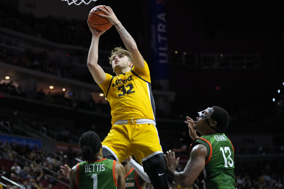 Iowa forward Owen Freeman (32) shoots over Florida A&M guard Love Bettis (1) and forward Shannon Grant (13) during the first half of an NCAA college basketball game, Saturday, Dec. 16, 2023, in Des Moines, Iowa. (AP Photo/Charlie Neibergall)