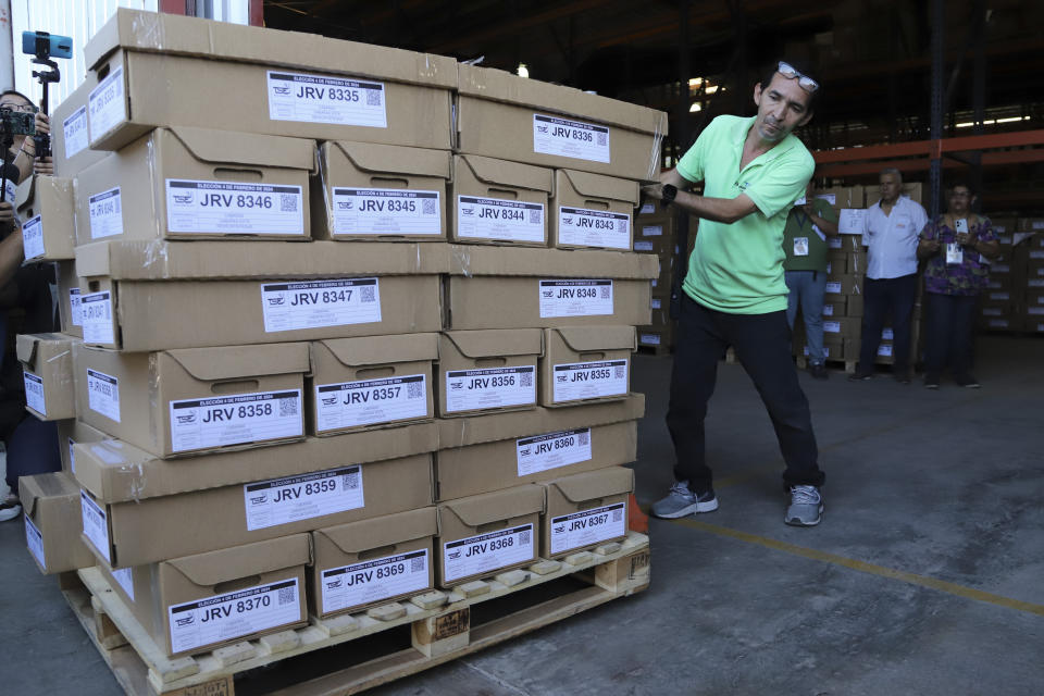 An electoral worker stackes boxes with electoral supplies, in San Salvador, El Salvador, Tuesday, Jan. 23, 2024. El Salvador will hold presidential elections on Feb. 4. (AP Photo/Salvador Melendez)