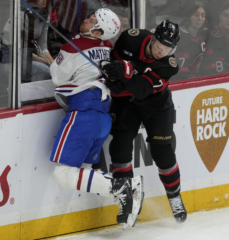 Ottawa Senators left wing Brady Tkachuk, right, sends Montreal Canadiens defenseman Mike Matheson into the boards during first-period NHL hockey game action Thursday, Jan. 18, 2024, in Ottawa, Ontario. (Adrian Wyld/The Canadian Press via AP)