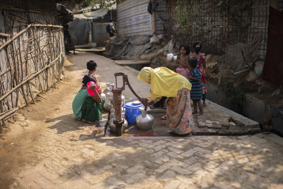 A Rohingya refugee woman collects drinking water from a well at a refugee camp in the Cox's Bazar district of Bangladesh, on March 9, 2023. (AP Photo/Mahmud Hossain Opu)