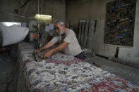 Iranian Ali Akbar Sayyahi puts the finishing touch to a hand-woven carpet at a workshop at the traditional bazaar of the city of Kashan, about 152 miles (245 km) south of the capital Tehran, Iran, Tuesday, April 30, 2024. (AP Photo/Vahid Salemi)