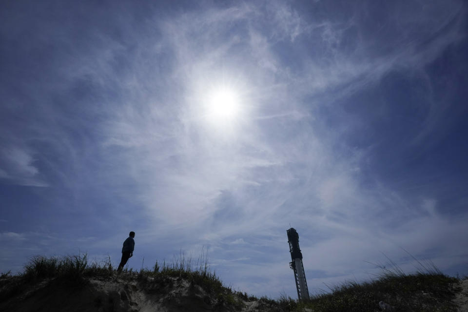 A man walks past the site where SpaceX's Starship, the world's biggest and most powerful rocket, sits ready for launch in Boca Chica, Texas, Sunday, April 16, 2023. The test launch is scheduled for Monday. (AP Photo/Eric Gay)