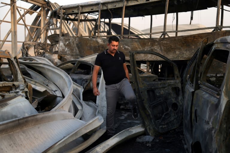 An Iraqi inspects the wreckage after gunmen and suicide bombers killed dozens of people near the southern city of Nasiriyah on September 14, 2017