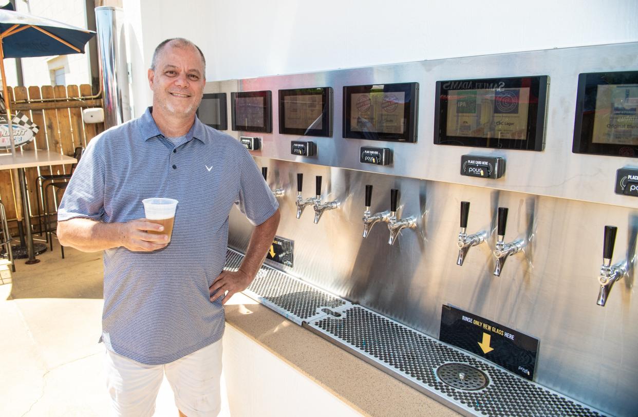 Owner Keith Bordner stands beside the self-pour beverage wall June 27 at Cardo's Pizza & Tavern, 7897 Refugee Road. The wall has 24 taps – 20 beers, two varieties of wine and two custom cocktails.