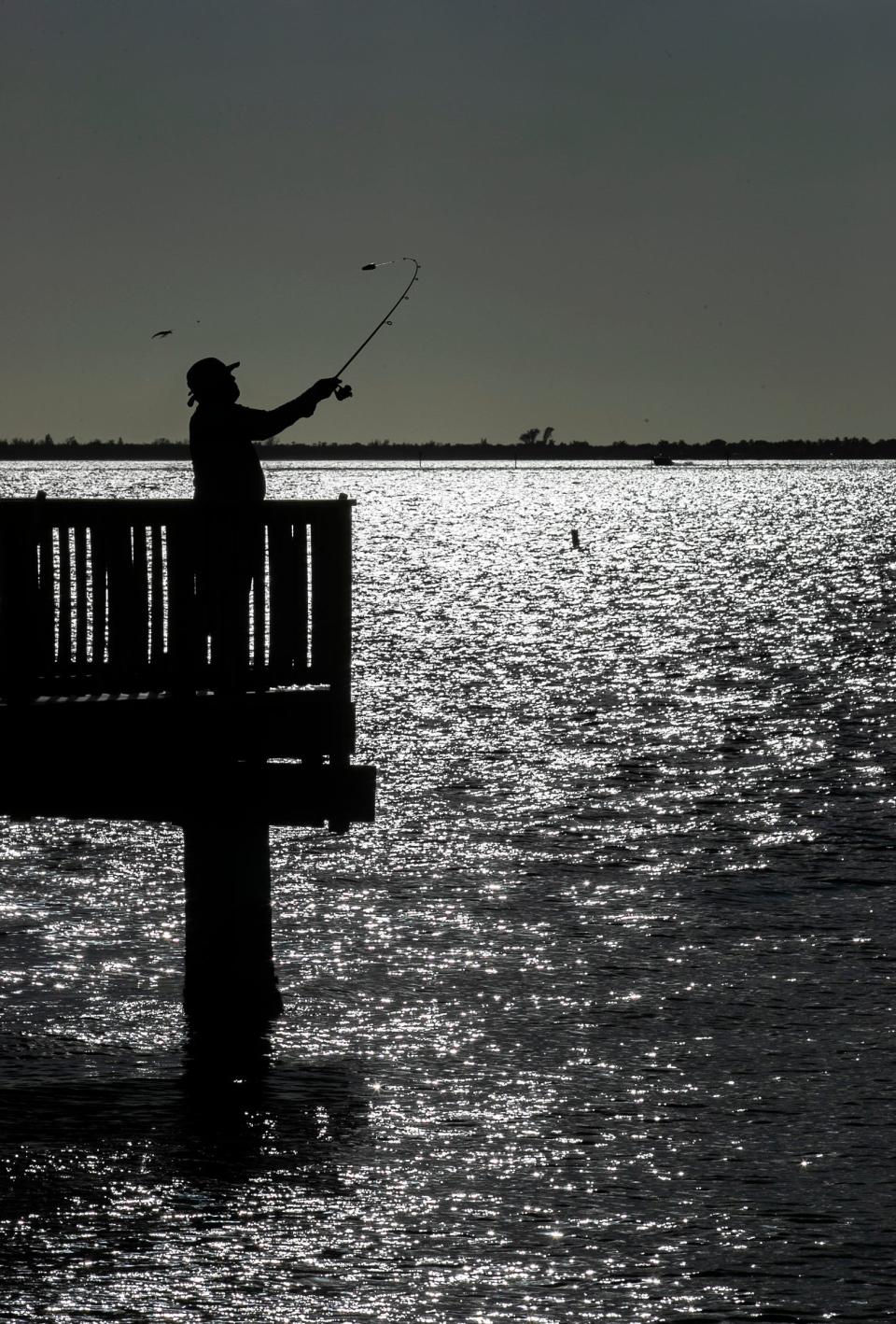 Hansel Pham, visiting from Washington D.C., fishes off the Cape Coral Yacht Club pier Wednesday, November 24, 2021. 