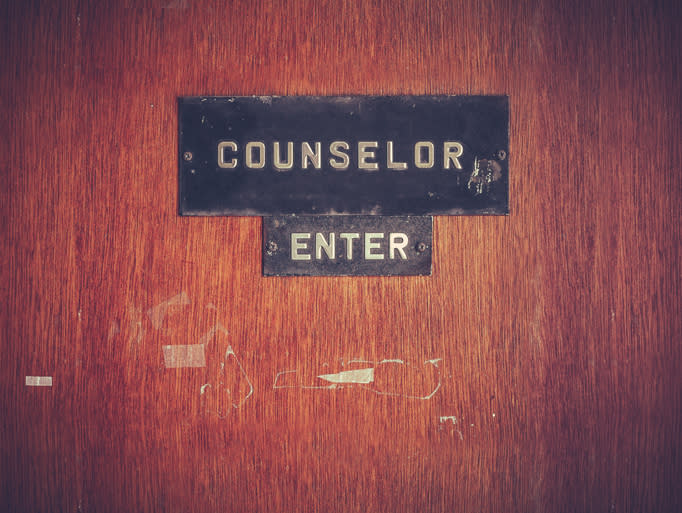 A worn wooden door with a sign reading "COUNSELOR" above a smaller "ENTER" sign