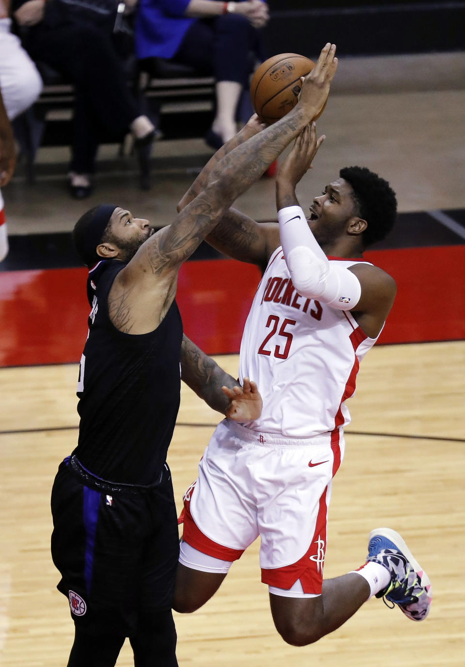 Houston Rockets' Cameron Oliver (25) drives on Los Angeles Clippers' DeMarcus Cousins (15) during the fourth quarter of an NBA basketball game Friday, May 14, 2021, in Houston. (Bob Levey/Pool Photo via AP)