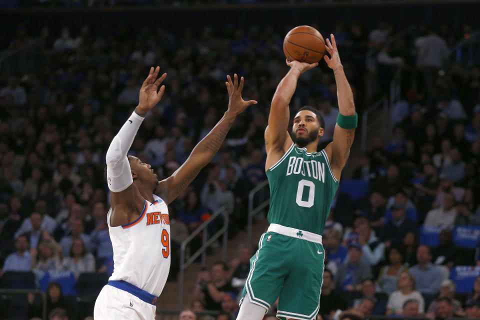 Boston Celtics forward Jayson Tatum (0) shoots over New York Knicks guard RJ Barrett (9) during the first half of an NBA basketball game Wednesday, Oct. 25, 2023, in New York. (AP Photo/John Munson)