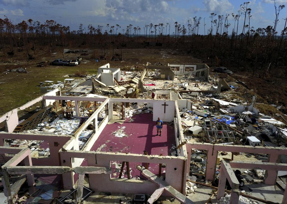 Pastor Jeremiah Saunders poses for a photo among the ruins of his church that was destroyed by Hurricane Dorian, in High Rock, Grand Bahama, Bahamas, Wednesday Sept. 11, 2019. Jeremiah says "I spoke to the water: 'Peace, be still.' It never listened," Saunders said with a wide smile and then grew serious as he focused on the task that tens of thousands of Bahamians now face on two islands devastated by the Category 5 storm: the clean-up. (AP Photo / Ramon Espinosa)