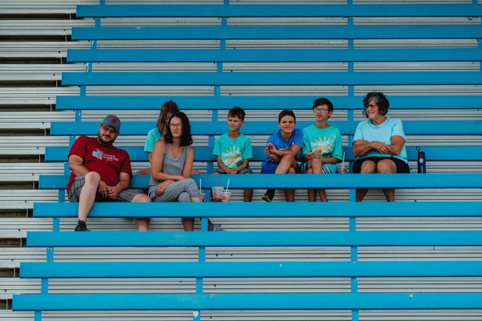 A family watches the  water-barrel competition between firefighters during the fourth annual HRN Firefighter Field Day, Saturday, June 10 at the Tuscarawas County Fairgrounds in Dover. Proceeds from the event went to benefit the Akron Children’s Hospital Burn Camp program.