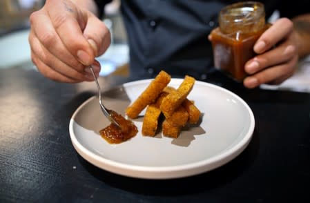 Chef Mario Barnard plates Mopane worm and polenta fries with tomato chilli chutney at the Insect Experience Restaurant in Cape Town