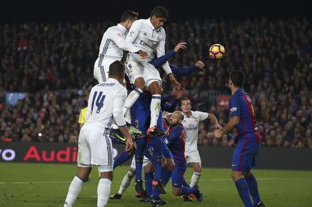 Football Soccer - Barcelona v Real Madrid - Spanish La Liga Santander- Nou Camp Stadium, Barcelona, Spain - 3/12/16. Real Madrid's Cristiano Ronaldo and Raphael Varane challenge Barcelona's Gerard Pique during the "Clasico". REUTERS/Sergio Perez