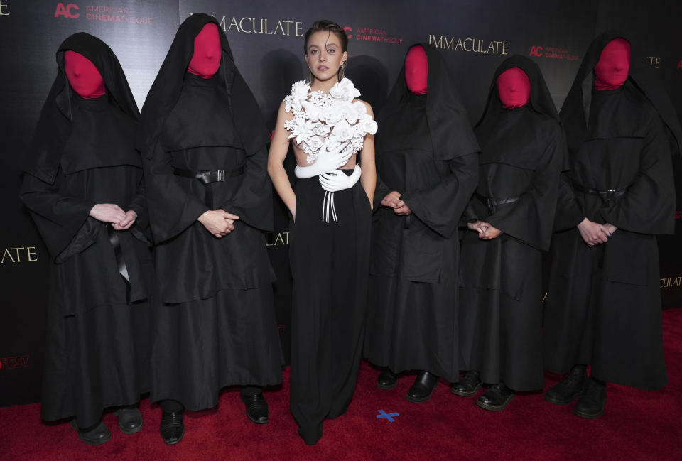 Sydney Sweeney, centro, posa con personajes de la película "Immaculate" en el estreno del filme el viernes 15 de marzo de 2024, en Los Ángeles. (Foto Jordan Strauss/Invision/AP)