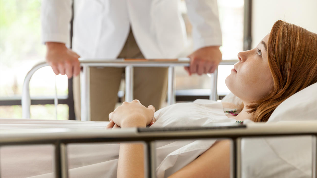  Focus on a teenage patient as a doctor checks in on them. 