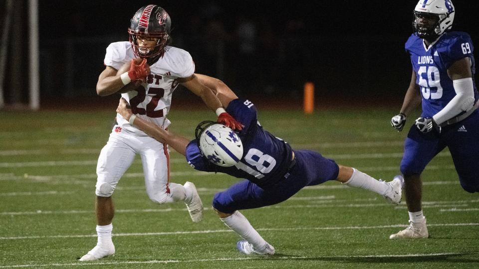 Cherry Hill East's Denzel Lee breaks the tackle of Cherry Hill West's Ryan Breeze as Lee runs the ball during the football game played at Cherry Hill West on Thursday, October 26, 2023.