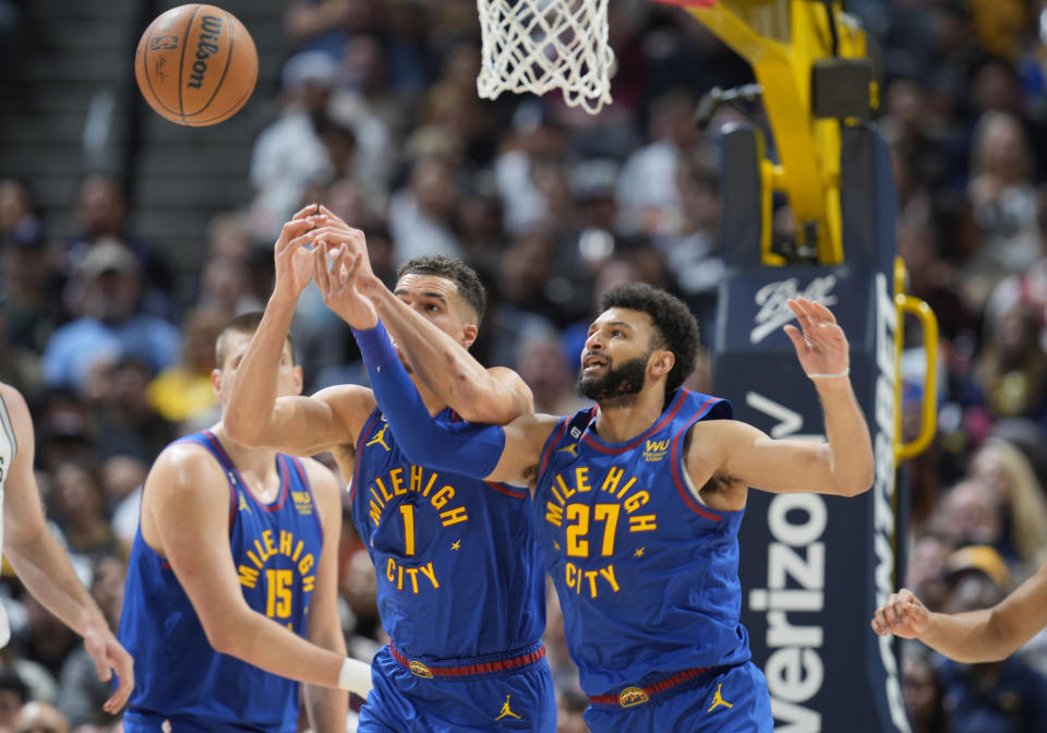 Denver Nuggets forward Michael Porter Jr., left, and guard Jamal Murray battle for control of a rebound in the second half of an NBA basketball game against the San Antonio Spurs, Saturday, Nov. 5, 2022, in Denver. (AP Photo/David Zalubowski)