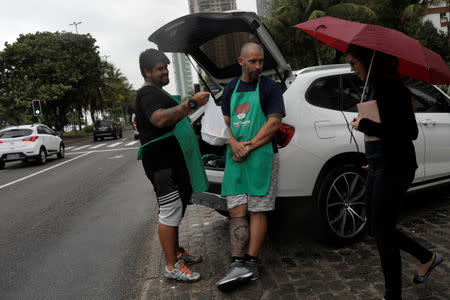 Stefan Weiss (L) and Alexander Costa sell food out of the trunk of a car in Rio de Janeiro, Brazil September 17, 2018. REUTERS/Ricardo Moraes