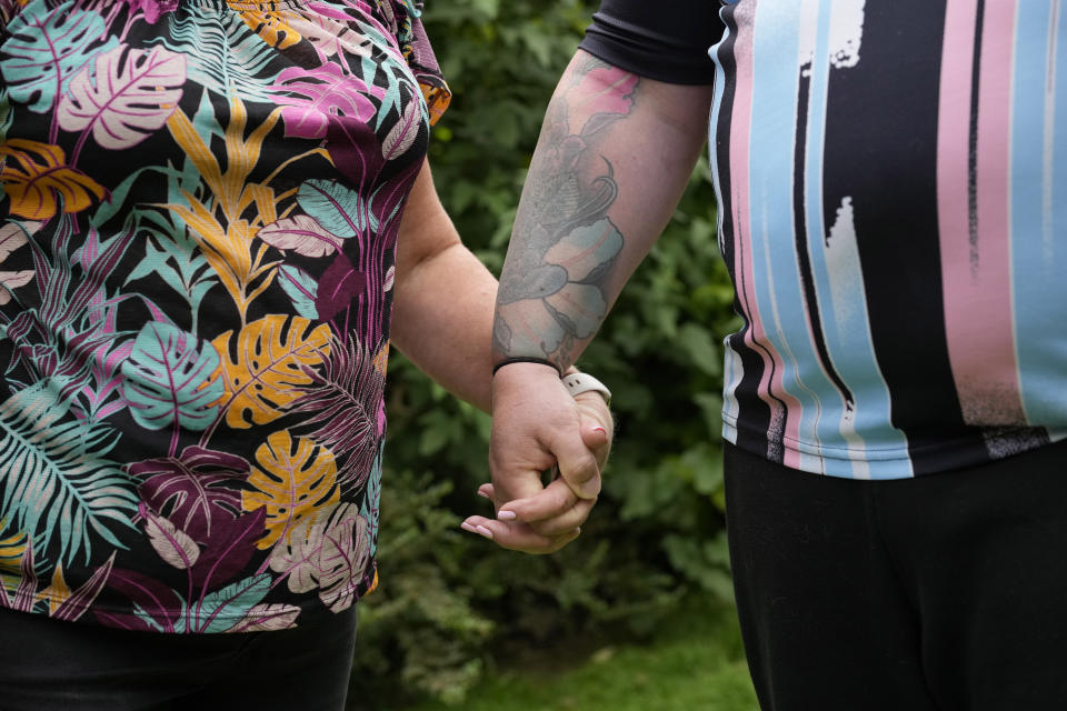 Avril Clark, left, and Lucy pose for a photograph during an interview at their house in London, Tuesday, June 11, 2024. Avril Clark operates the group Distinction Support, a U.K.-based global online network that helps people whose partner went through or is undergoing a gender transition. Her spouse, a British soccer referee at the time, came out publicly as transgender in 2018, changed her name to Lucy and brought the couple much attention. Avril Clark says that until then, they kept their arrangement private and "lived a double life" for 15 years. (AP Photo/Kin Cheung)