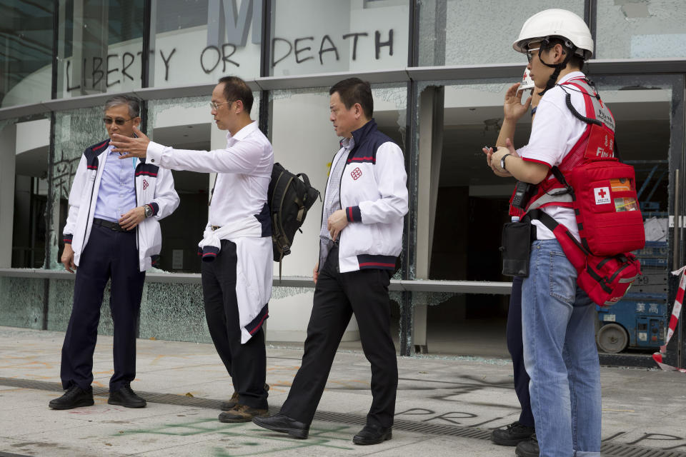 Prof. Alex Wai, second from left, a vice president with the Hong Kong Polytechnic University prepares to lead a team to look for holed up protesters on the university campus in Hong Kong, Tuesday, Nov. 26, 2019. Hong Kong's embattled leader Carrie Lam refused to offer any concessions to anti-government protesters despite a local election trouncing, saying Tuesday that she will instead accelerate dialogue and identify ways to address societal grievances. (AP Photo/Ng Han Guan)