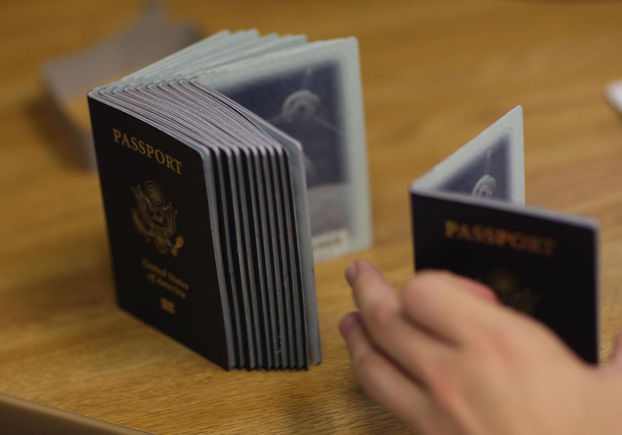 A Passport Processing employee uses a stack of blank passports to print a new one at the Miami Passport Agency: Joe Raedle/Getty Images