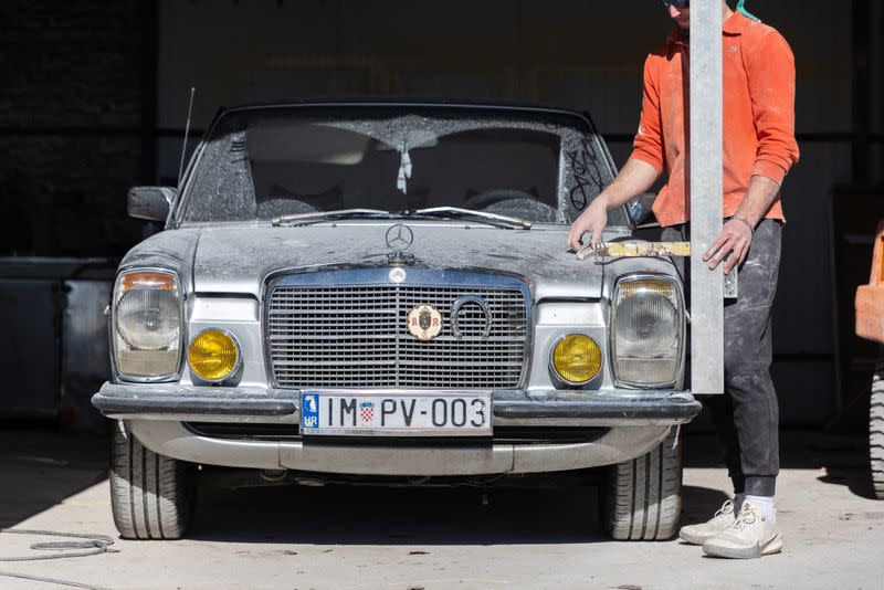 An artist works on a life size Mercedes monument in Imotski