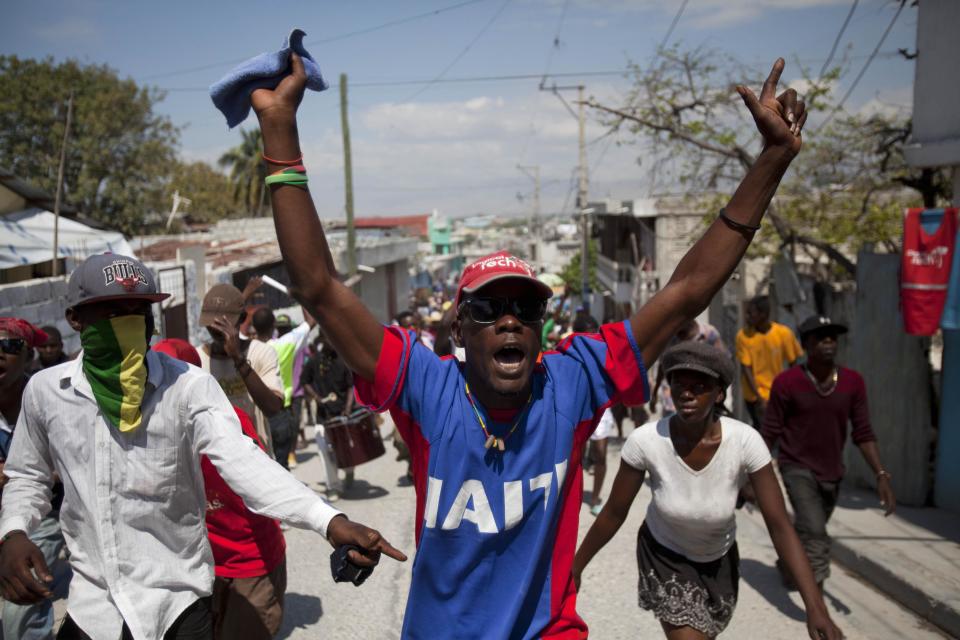 Demonstrators chant anti-government slogans during rally to mark the tenth anniversary of the second ouster of former President Jean-Bertrand Aristide, in Port-au-Prince, Haiti, Thursday Feb. 27, 2014. The protesters denounced what they described as widespread corruption in the government of President Michel Martelly and even called for his resignation. (AP Photo/Dieu Nalio Chery)