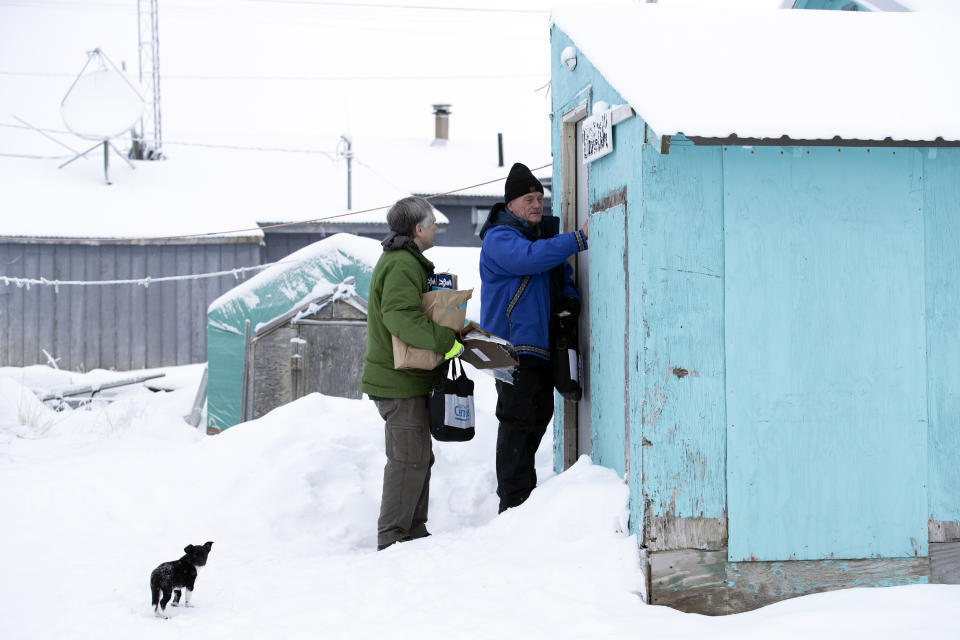 FILE - In this Jan. 21, 2020, file photo, Census Bureau director Steven Dillingham, right, knocks on the door alongside census worker Tim Metzger as they arrive to conduct the first enumeration of the 2020 Census in Toksook Bay, Alaska. Thousands of census takers are about to begin the most labor-intensive part of America’s once-a-decade headcount. The 2020 census started in January in rural Alaska where census takers visited homes much earlier than the rest of the country because of the difficulty in reaching those places. (AP Photo/Gregory Bull, File)