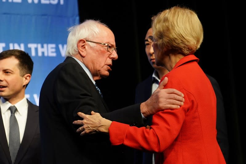 Bernie Sanders and Elizabeth Warren hug on stage at a First in the West Event at the Bellagio Hotel in Las Vega