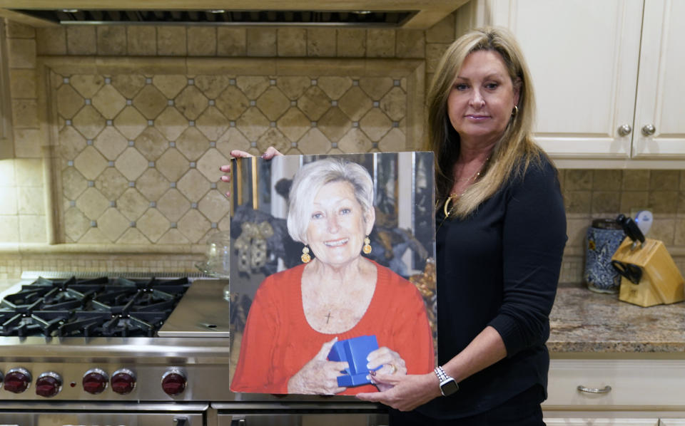 M.J. Jennings poses for a photo of her mother Leah Corken at her home in Dallas, Wednesday, Nov. 3, 2021. Jennings said she keeps the photo in the kitchen so she can cook with her mom watching. Corken was one of 18 women in the Dallas area that Billy Chemirmir is charged with capital murder and he is suspected in several more deaths. Most of the deaths happened at upscale independent living communities for older people, where Chemirmir has been accused of forcing his way into apartments or posing as a handyman, and in a couple instances was even caught trespassing. (AP Photo/LM Otero)