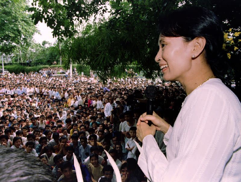 FILE PHOTO: Freed pro-democracry leader Aung San Suu Kyi smiles while speaking to hundreds of supporters from the gate at her residential compound in Yangon