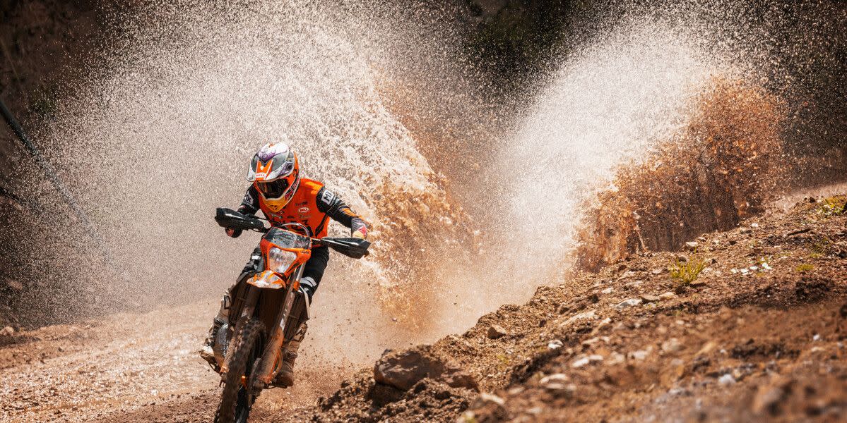 ktm's two stroke blasting through a puddle