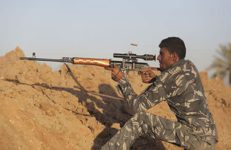 A Shi'ite fighter aims using a sniper rifle during a patrol in Jurf al-Sakhar October 25, 2014. REUTERS/Stringer