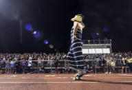 In this photo provided by Fritz Senftleber, people participate in the “drag ball" halftime show at Burlington High School on Friday, Oct. 15, 2021 in Burlington, Vt. The event was part of that school's homecoming and was sponsored by the Gender Sexuality Alliance from Burlington and South Burlington high schools. The football game was between a team made up of students from three Burlington-area schools Burlington, South Burlington and Winooski High Schools who played against St. Johnsbury Academy. (Fritz Senftleber via AP)