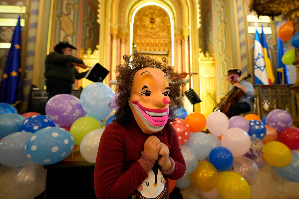 A child wearing a mask listens to a music show as Romania's Jewish community celebrates Purim at the Coral Temple synagogue in Bucharest, Romania, on March 6, 2023.