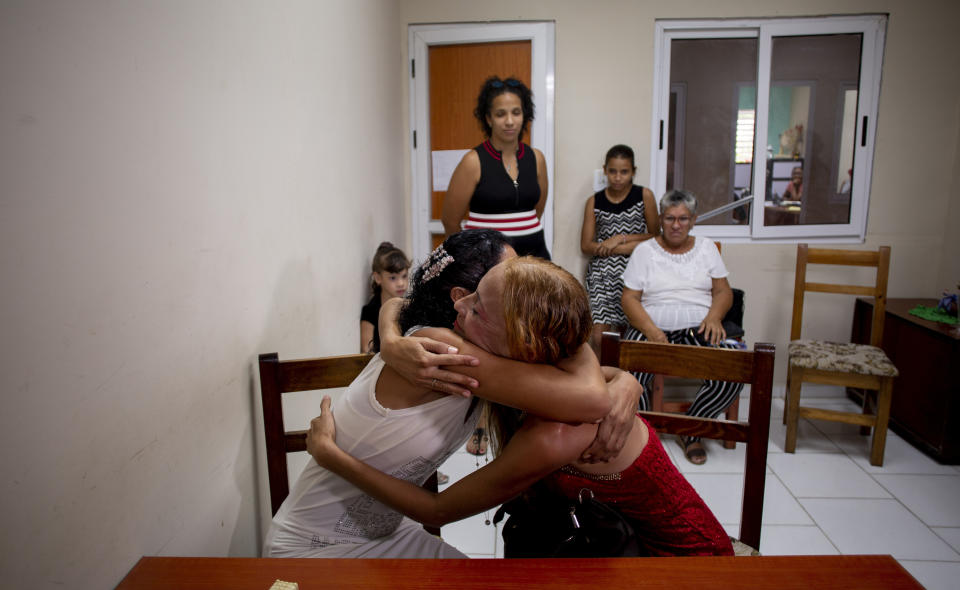 Newly-weds Lisset Diaz Vallejo, right, and Liusba Grajales hug after getting married at the notary office in Santa Clara, Cuba, Friday, Oct. 21, 2022. The couple, who have been together for seven years, is one of the first to make the decision to get legally married in Cuba following the new Family Code, which opened up everything from equal marriage to surrogate mothers. (AP Photo/Ismael Francisco)
