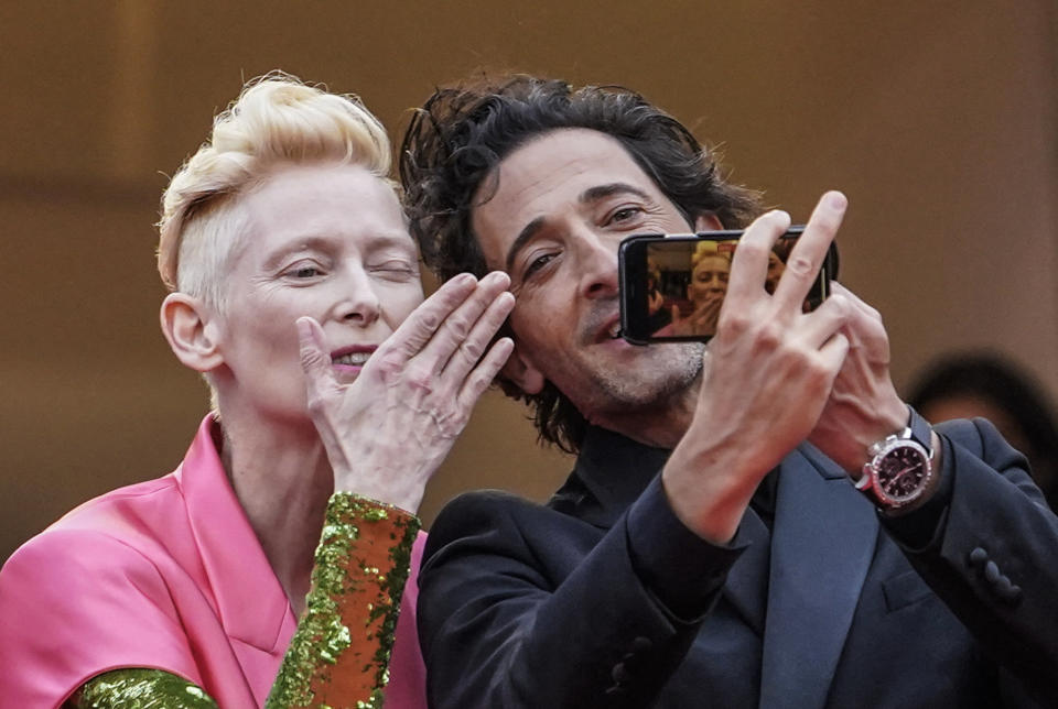 FILE - In this July 12, 2021 file photo Tilda Swinton, left, and Adrien Brody take a selfie photograph upon arrival at the premiere of the film 'The French Dispatch' at the 74th international film festival, Cannes, southern France. (AP Photo/Brynn Anderson, File)