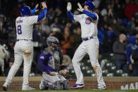 Chicago Cubs' Garrett Cooper, right, hive-fives Ian Happ after Cooper after hitting a three-run home run during the sixth inning of a baseball game against the Colorado Rockies, Tuesday, April 2, 2024, in Chicago. (AP Photo/Erin Hooley)