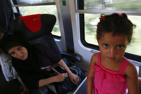 A woman looks at her daughter aboard a train with migrants on board en route from Budapest to Vienna, Austria, August 31, 2015. REUTERS/Laszlo Balogh