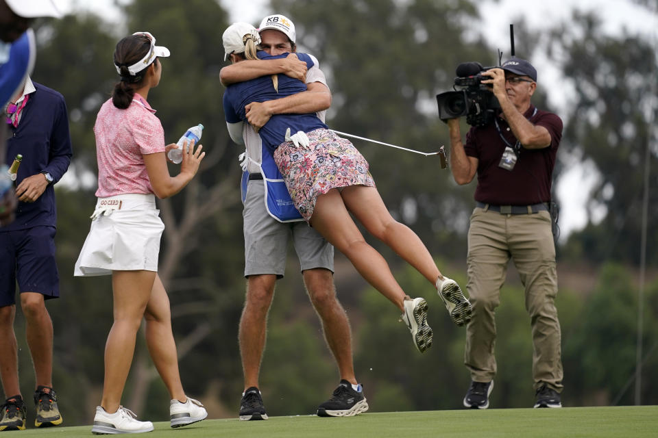 Jodi Ewart Shadoff, second from left, of England, hugs her caddie John Pavelko as Andrea Lee, left, after winning the MEDIHEAL Championship golf tournament Sunday, Oct. 9, 2022, in Camarillo, Calif. (AP Photo/Mark J. Terrill)