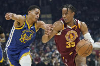 Cleveland Cavaliers' Isaac Okoro (35) drives against Golden State Warriors' Jordan Poole (3) in the first half of an NBA basketball game, Thursday, Nov. 18, 2021, in Cleveland. (AP Photo/Tony Dejak)