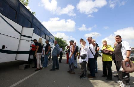 Passengers who were onboard an Air France Boeing 777 aircraft that made an emergency landing board a bus as they are escorted to hotels from Moi International Airport in Kenya's coastal city of Mombasa, December 20, 2015. REUTERS/Joseph Okanga