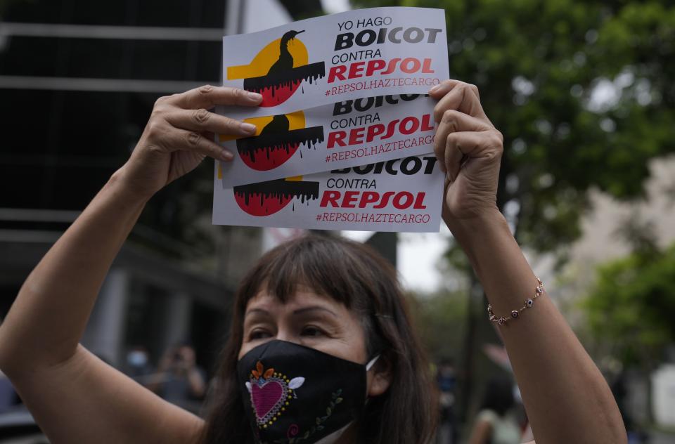 A demonstrator protests in front of the Repsol office in Lima, Peru, Thursday, Jan. 26, 2022. The demonstrators were there to protest after Peru declared an environmental emergency after announcing that 21 beaches on the Pacific coast were contaminated by an oil spill at a refinery run by Spain-based Repsol, following surging waves caused by the eruption of an underwater volcano near Tonga. (AP Photo/Martin Mejia)