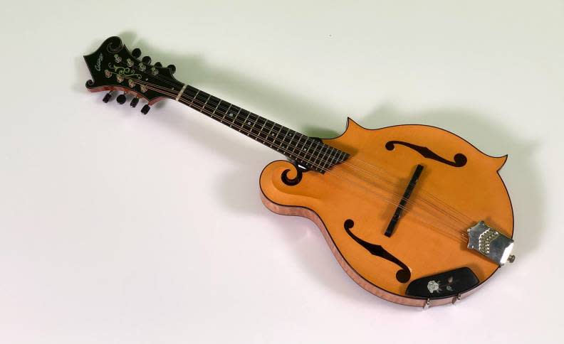 尤秋興買了一把曼陀林，圓了想學小提琴的夢。華研國際音樂提供
