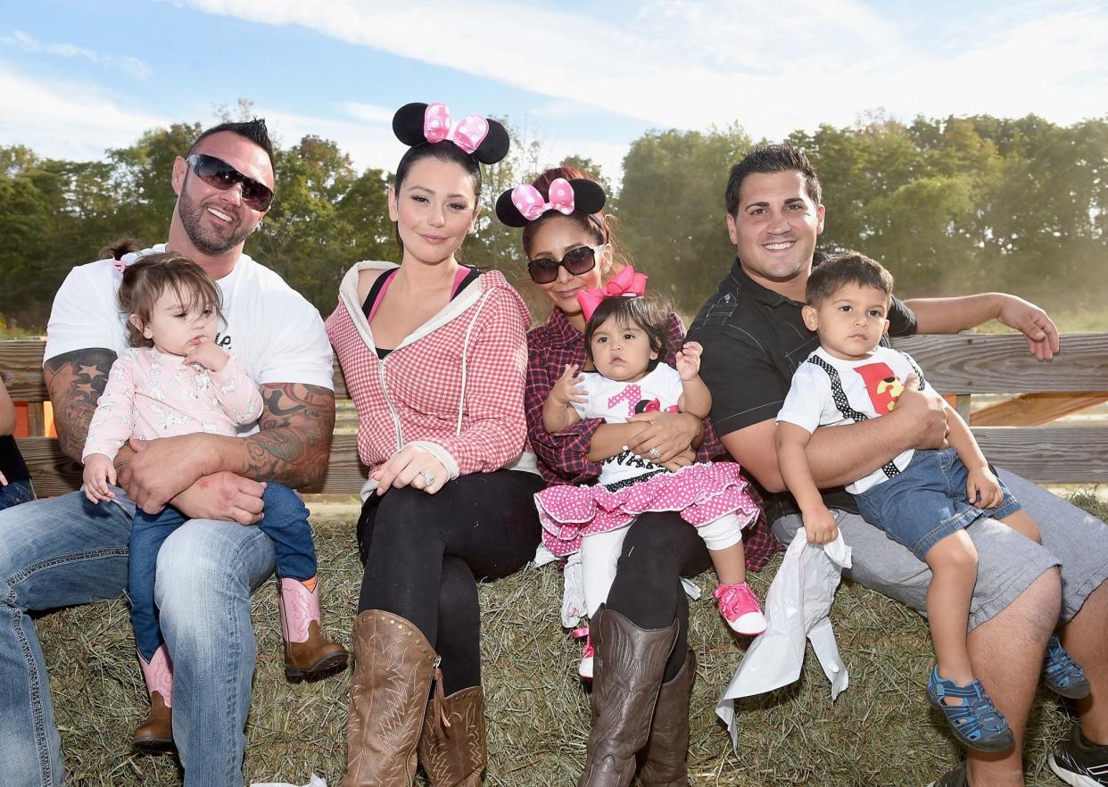 Jenni 'JWoww' Farley and Nicole 'Snooki' Polizzi pose with their spouses and children in September 2015. (Photo: Getty Images)