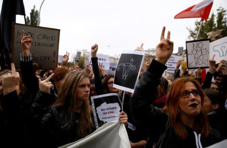 A woman gestures as people gather in an abortion rights campaigners' demonstration to protest against plans for a total ban on abortion in front of the ruling party Law and Justice (PiS) headquarters in Warsaw, Poland October 3, 2016. Picture taken October 3, 2016. REUTERS/Kacper Pempel